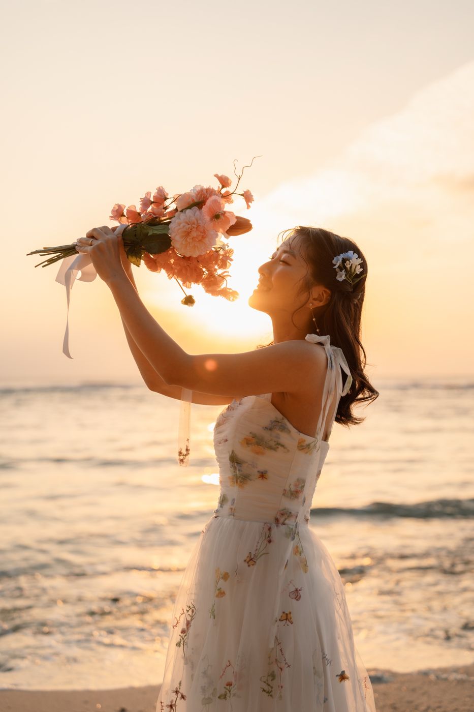 夕日にブーケを掲げて笑う花嫁